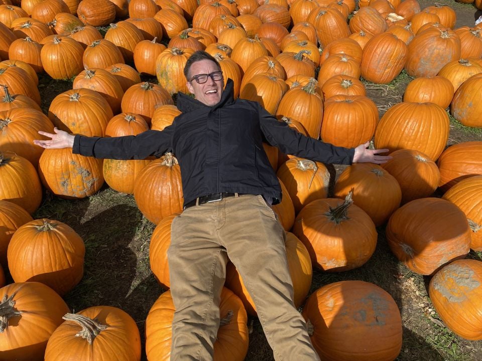 The author laying on a pile of pumpkins